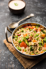 Broken wheat or Daliya Upma, served in a bowl. selective focus