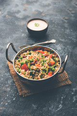Broken wheat or Daliya Upma, served in a bowl. selective focus