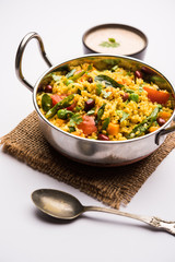 Broken wheat or Daliya Upma, served in a bowl. selective focus