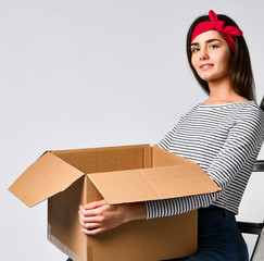 Delivery, relocation and unpacking. Smiling young woman holding cardboard box isolated on white background