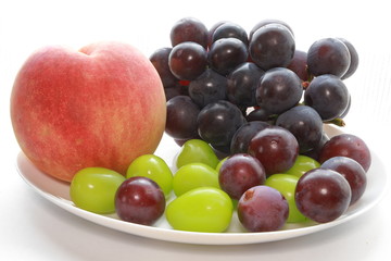 Black grape, green grape and peach on the table