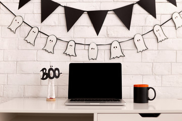 Workplace decorating for Halloween party with open laptop