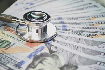 medical cost rising, stethoscope on dollar banknote money. concept of health care costs, finance,...