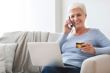 Mature lady shopping online with credit card and laptop