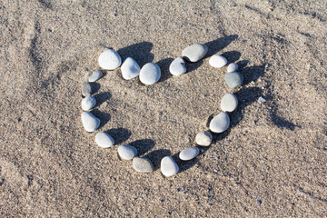 A heart made with stones on a sandy beach