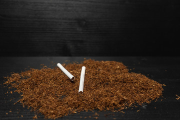 Raw tabaco on black wood background with copy space for text