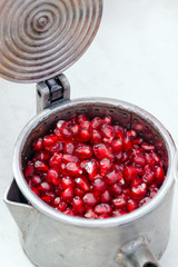 Pomegranate seeds in a manual juicer