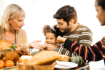Thanksgiving Celebration Tradition Family Dinner Concept.family having holiday dinner and cutting turkey.Young black adult woman and her daughter happy.