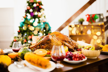 Roasted  chicken or turkey with sauce and grilled autumn vegetables: corn,pumpkin  on wooden table, top view, frame. Christmas or Thanksgiving Day food concept.