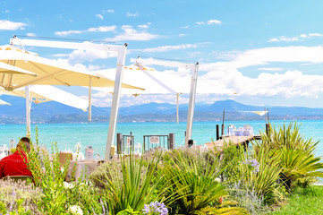 Served table for a wedding by the lake. Deep water, mountains and sky. Romantic day