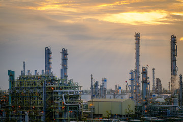 Furnace and gas refinery tower in petrochemical industrial plant on sunset sky background