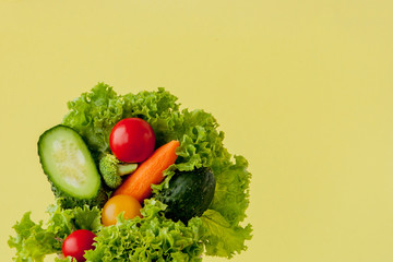 Fresh vegetables on scales on yellow background. Vegan and healthy concept.