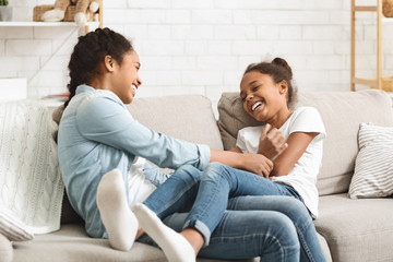 Cute black sisters having fun together at home - obrazy, fototapety, plakaty