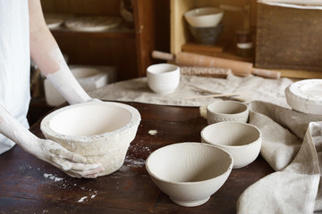 Female hands hold a bowl for casting clay products. Shaped method for making clay dishes. Handwork. Pottery making