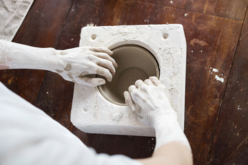 Female hands hold a bowl for casting clay products. Shaped method for making clay dishes. Handwork....