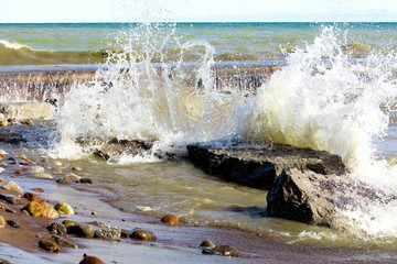 spray from waves hitting rocks on a beach