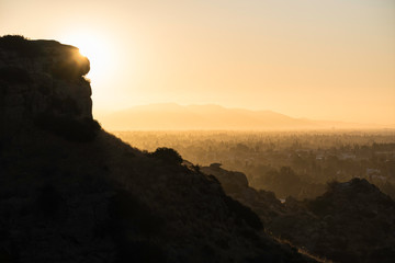 Hazy San Fernando Valley dawn view from the Santa Susana Mountains in the city of Los Angeles, California.  The San Gabriel Mountains are in the background.