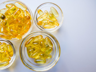 Fish oil capsules on a glass plate. A lot of vitamin omega 3 on a white background. Close-up, top...