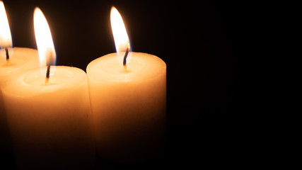 Burning candles on a black background with space to put any text