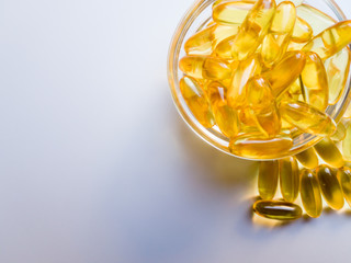 Fish oil capsules on a glass plate. A lot of vitamin omega 3 on a white background. Close-up, top...