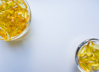 Fish oil capsules on a glass plate. A lot of vitamin omega 3 on a white background. Close-up, top...