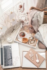 Toned photo. Autumn decor. A laptop, a mug of hot tea, a bun, candles. Cozy. Autumn.