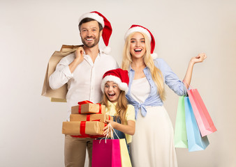 Family In Santa Hats Holding Gifts And Shopping Bags, Studio