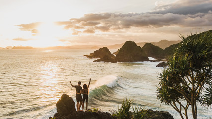 Couple enjoying sunset with amazing ocean and mountain view. Travel concept, panoramic shot, wanderlust. - 293184076