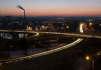Fototapeta na wymiar Evening sub-urban scene with the busy intersection, bridge and river