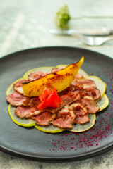 duck meat carpaccio with pear flambe (tasty snack, aperitif) menu concept. food background. copy space. Top view