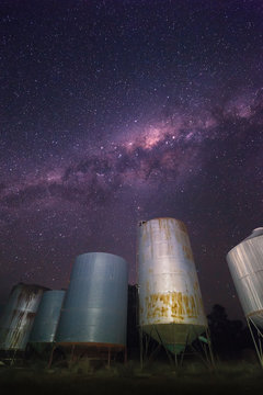 Milky way over a Row of Metal Grain silos on a farm, Australia