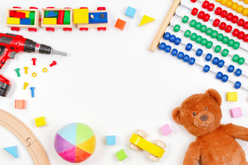 Baby kids toys background with teddy bear, toy tools, wooden train, cars and colorful blocks. Top view, flat lay