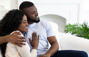Fototapeta premium Closeup portrait of smiling africam american couple cuddling at home