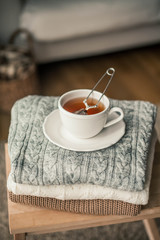 Toned photo. Autumn decor. A mug of hot tea, Knitted sweaters . Cozy. Autumn.