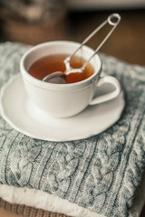 Toned photo. Autumn decor. A mug of hot tea, Knitted sweaters . Cozy. Autumn.