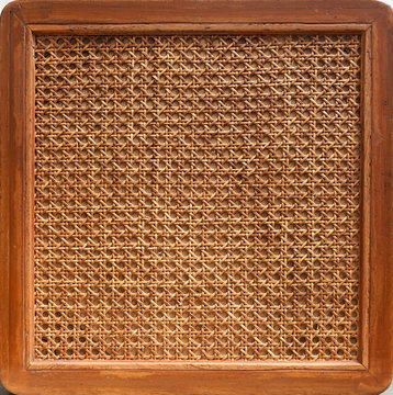 Rattan chair. A closed up details pattern formed by rge open weave rattan cane on a chair seat. texture and background of a woven chair.