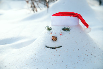 Cheerful snowdrift, snowman in anticipation of waiting for Christmas holidays in a snowy forest.