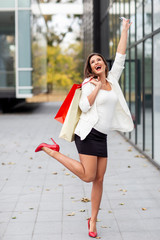 Beautriful young woman with shopping bags on her hands smile