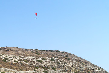 Fototapeta na wymiar Paraglider in the sky over a mountain slope 