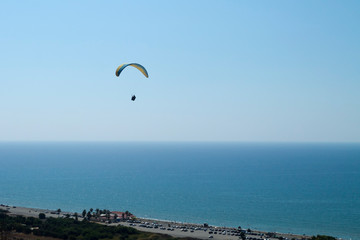Paraglider in the sky over sea coastline