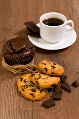 Chocolate muffin on a brown table. A cup of coffee. shortbread.
