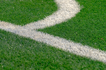White stripe on the artificial green soccer football field. Top view