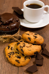 Chocolate muffin on a brown table. A cup of coffee. shortbread.