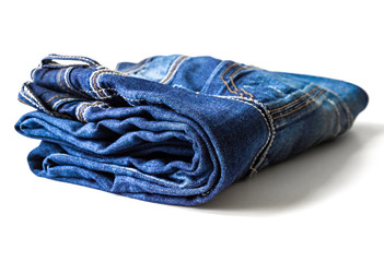 Jeans stacked on white background. Stack of various shades of blue jeans on white background.