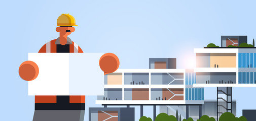male builder architect holding blueprint workman engineer with empty placard board industrial worker in uniform building concept modern office exterior flat portrait horizontal