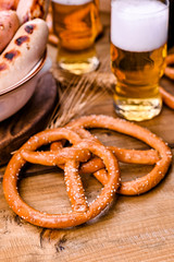 Fresh beer with foam on a wooden background. Oktoberfest German Pretzels