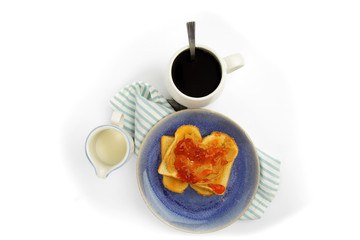 overhead view of a table setting of peanut butter and jam on white toast isolated on white