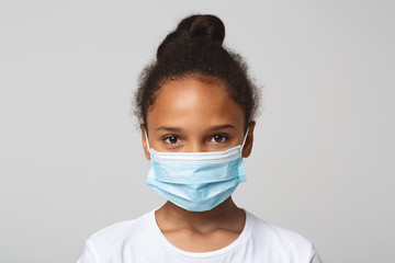 Portrait of little black girl wearing medical mask
