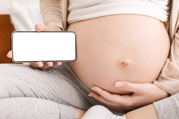 Pregnant woman holding cellphone near her big belly