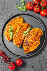 Honey mustard grilled chicken breasts, cast iron skillet, dark background. Top view.